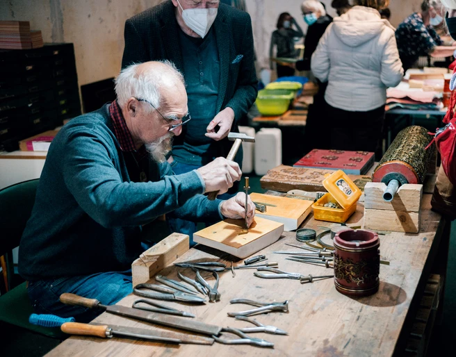 Druckerbande aus Einbeck Ein Mann beschäftigt sich handwerklich bei der Druckerbande.