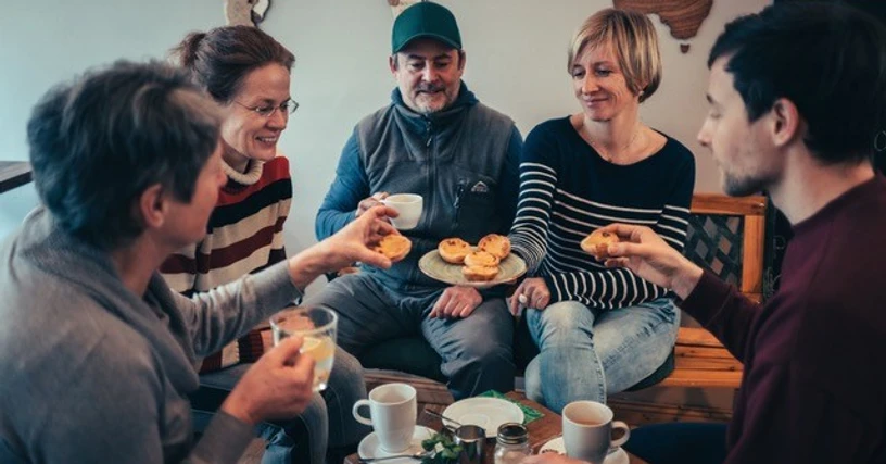 allerleipzig - Kulinarische Stadtführungen - Stadtführungen in Leipzig Eine Gruppe Menschen sitzt mit Kaffee zusammen und probiert süße Pasteis im Rahmen der kulinarischen Stadtführung von allerleipzig.