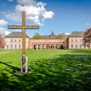 Alter Johannisfriedhof - Kultureinrichtungen in Leipzig Blick auf das Holzkreuz das an die zerstörte Johanniskirche erinnert und das Gebäude der Grassi Museen für Völkerkunde Musikinstrumente und angewandte Kunst am Johannisplatz in denen man wunderbare Ausstellungen betrachten kann, Kultureinrichtung in Leipzig, Museum, Geschichte, Kultur