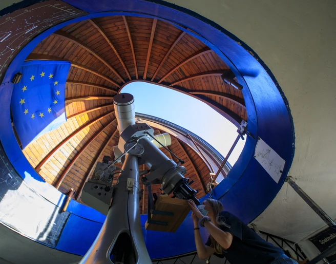 Astronomisches Zentrum Schkeuditz - Sehenswürdigkeiten in der Leipzig Region Blick ins Innere des Observatoriums, an dem eine junge Frau durch das Teleskop in den Himmel schaut, Wissenschaft, Observatorium, Sternwarte, Freizeit
