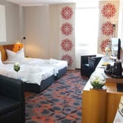 Deluxe Zimmer im Atlanta Hotel - Unterkünfte in der Leipzig Region Innenansicht des Hotelzimmers mit Doppelbett, Sessel und weiterer Inneneinrichtung, Unterkunft, Urlaub, Kurzurlaub