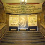 Treppenaufgang im Museum in der Runden Ecke - Friedliche Revolution in Leipzig Blick vom unteren Ende des Treppenaufgangs auf mehrere Banner und Poster, die auf das Museum in der Runden Ecke hindeuten, Friedliche Revolution, Geschichte, Freizeit, Sehenswürdigkeiten