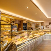 Bäckerei und Konditorei Göbecke - Cafés in Leipzig Blick in die Bäckerei und Konditorei Göbecke sowie auf die lange, erleuchtete Ladentheke, Kulinarik, Gastronomie