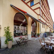 Eisträumerei Leipzig - Eisdielen & Cafés in Leipzig Eckansicht des Außenbereiches der Eisträumerei mit Café-Garnituren, Schaufenstern, Pflanzen und den angrezenden Straßenzug, freisitz, cafe, eisdiele