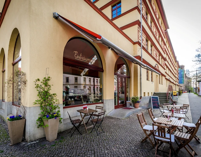 Eisträumerei Leipzig - Eisdielen & Cafés in Leipzig Eckansicht des Außenbereiches der Eisträumerei mit Café-Garnituren, Schaufenstern, Pflanzen und den angrezenden Straßenzug, freisitz, cafe, eisdiele