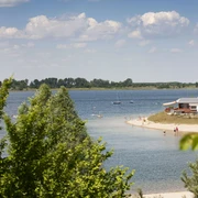 Schladitzer See - Leipziger Neuseenland Zwischen grünen Bäumen blickt man auf den Schladitzer See und dem Strandufer