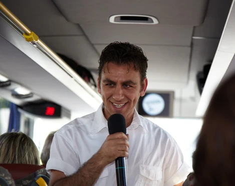 Comedytour - Erlebnisse in Leipzig Ein Mann im Bus der Stadtrundfahrt der Comedytour mit Mikrofon in der Hand