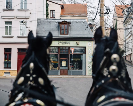 Drogerie - Gastronomie in Leipzig Blick auf die Außenfassade des Restaurant Drogerie in Leipzig mit Zugpferden und Tram im Vordergrund