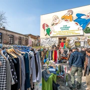 Flohmarkt auf der Feinkost Leipzig - Freizeiterlebnisse in Leipzig Flohmarkt mit vielen Besuchern vor der Leuchtreklame Löffelfamilie auf dem Gelände der Feinkost
