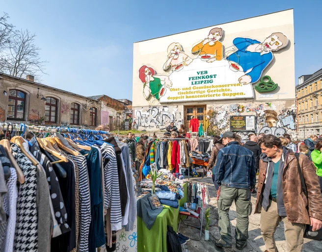 Flohmarkt auf der Feinkost Leipzig - Freizeiterlebnisse in Leipzig Flohmarkt mit vielen Besuchern vor der Leuchtreklame Löffelfamilie auf dem Gelände der Feinkost