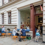 Gustav H. - Eisdielen & Eiscafés in Leipzig Blick auf die Fassade und den Freisitz des Gustav H., mit schlemmenden Gästen und spielenden Kindern, eisdiele, eiscafe, gastronomie