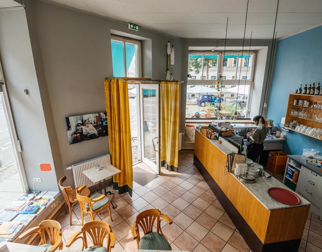 Jimmy Orpheus - Cafés in Leipzig Blick inn das farbenfrohe Jimmy Orpheus-Café aus der Vogelperspektive; mit Blick auf Sitzbereich, Theke, Fensterfronten