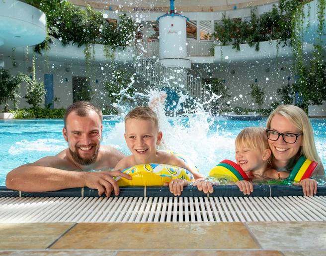 Riff-Bad-Lausick-Freizeit-Familie-Ausflug-Kur-und-Freizeitbad-RIFF-Bad-Lausick-Leipzig-Travel.jpeg Eine Familie mit 2 Kindern plantscht am Beckenrand des RIFF's, Schwimmbad-Leipzig-mit-Kindern-Freizeit