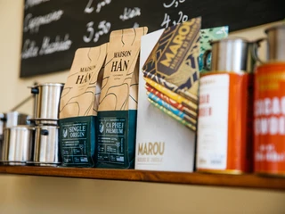 Le caphe - Cafés in Leipzig Detailaufnahme der ausgewählten Produkte im Regal des le caphe sowie die beschriftete Tafel im Hintergrund, cafe, gastronomie, kulinarik