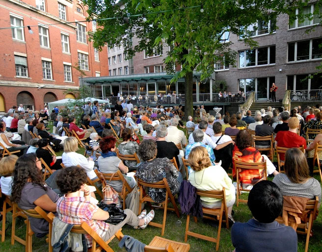 Haus des Buches - Moderne Architektur in Leipzig Der Innenhof des Haus des Buches ist beim Sommerfest des Literaturcafés voller Menschen, Veranstaltungen, Buchstadt, Kultureinrichtung, Architektur in Leipzig