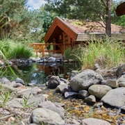 Saunadorf Oschatz - Wellness in der Leipzig Region Blick auf das Saunadorf mit kleinen Holzhütten an einem Bach in Oschatz gelegen