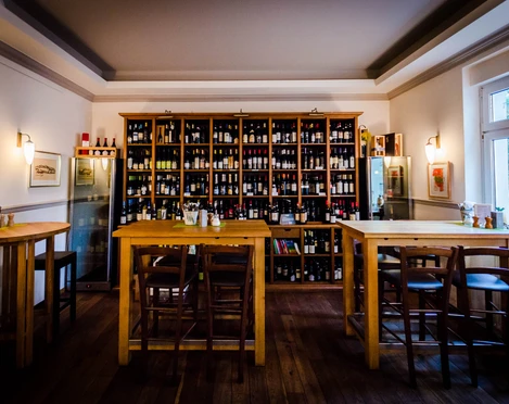 Salumeria Italiana - Gastronomie in Leipzig Blick in das Feinkostgeschäft mit Bistro; Sitzbereich, Holzregale mit Weinvielfalt und herrliche Beleuchtung, restaurant, gastronomie