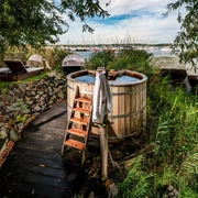 Badezuber Sauna im See - Wellness in Leipzig und Region Ein Badezuber und Liegen zum Entspannen stehen in dem Außenbereich der Wellness-Einrichtung Sauna im See.