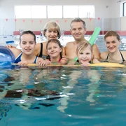 Sportbad Markkleeberg - Wasserspaß in Leipzig und Region Eine Familie mit Kindern in Nahaufnahme im Schwimmbecken des Sportbad Markkleeberg, die Kinder haben Schwimmnudeln und einen Wasserball zum Spielen, Ausflug, Freizeit