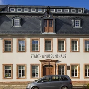 Stadt- und Museumshaus Waldheim - Sehenswürdigkeiten in der Leipzig Region Blick auf das weiß gestrichene Stadt- und Museumshaus Waldheim und schwarzem Dach, davor ein Auto parkend, Region Leipzig, Ausstellungen, Ausflug