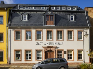 Stadt- und Museumshaus Waldheim - Sehenswürdigkeiten in der Leipzig Region Blick auf das weiß gestrichene Stadt- und Museumshaus Waldheim und schwarzem Dach, davor ein Auto parkend, Region Leipzig, Ausstellungen, Ausflug