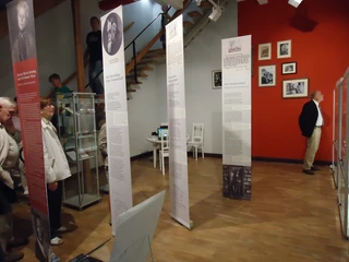 Stadtmuseum Döbeln Innenansicht des Stadtmuseums Döbeln mit stehenden Figuren und Informationsstelen, eine Galerie mit Fotos an der roten Wand.