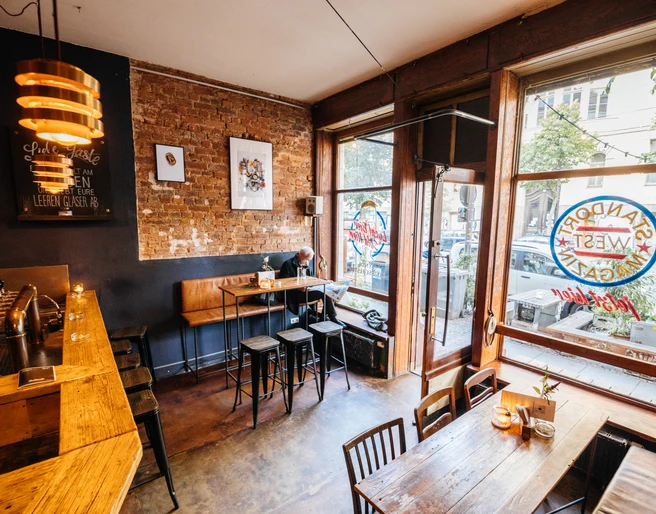 Subbotnik - Kneipen & Bars in Leipzig Blick in das Subbotnik, auf seine Tische, Inneneinrichtung und die Schaufenster sowie die angrenzende Straße von Innen, kneipe, bar, freizeit