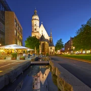 Thomaskirche Leipzig - Musikstadt Leipzig Blick auf die angestrahlte Thomaskirche in der Abend-Dämmerung, links davor das Brauhaus mit Freisitz und rechts davon die grüne Thomaswiese mit Bäumen, Kultureinrichtung, Freizeit, Musik, Bach