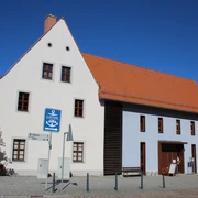 Tourist-Information Belgern Die Tourist-Information befindet sich in einem weißen Eckhaus im Stadtkern .