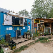 Zum Wilden Heinz - Cafés in Leipzig Blick auf den blauen Ausschank-Wagen sowie den angrenzenden Holzverschlag im "Zum Wilden Heinz"-Biergarten, freisitz, gastronomie