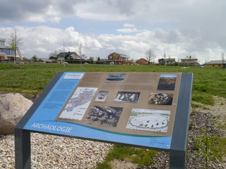 Geologischer Lehrpfad am Zwenkauer See Eine Informationstafel am Zwenkauer See zeigt archäologische Fundstücke in einer ländlichen Landschaft.