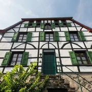 Altes Doktorhaus in Haan-Gruiten Fachwerkhaus mit grünen Fensterläden, historische Architektur, vor klarblauem Himmel.