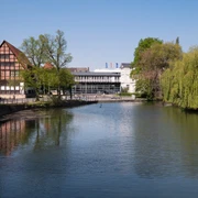 Blick auf das Lippische Landesmuseum Eine ruhige Flusslandschaft mit reflektierendem Wasser; im Hintergrund das Lippische Landesmuseum.