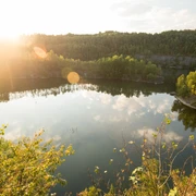 Steinbruch Schlupkothen bei Wülfrath Sonnenstrahlen über dem Steinbruch Schlupkothen spiegeln sich malerisch im ruhigen Wasser wider.