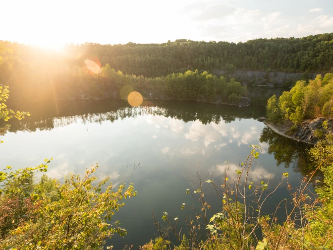 Steinbruch Schlupkothen bei Wülfrath Sonnenstrahlen über dem Steinbruch Schlupkothen spiegeln sich malerisch im ruhigen Wasser wider.