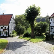 Einladender Hofladen auf dem Biohof Judt im Windrather Tal Ein Hofladen umgeben von Fachwerkhäusern und grünen Bäumen lädt im Windrather Tal zum Einkauf ein.