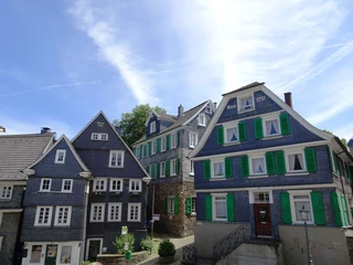 Abstecher ins historische Velbert-Langenberg Historische Fachwerkhäuser in Velbert-Langenberg vor einem klaren, blauen Himmel mit dekorativen Fensterläden.