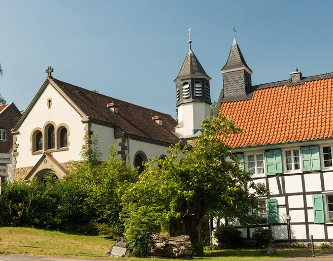 Abtskücher Kapelle St. Jakobus und Hof in Heiligenhaus Abtskücher Kapelle St. Jakobus in Heiligenhaus, umgeben von Grün, mit historischem Fachwerkhaus.