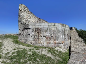 Ruinen der Falkenburg in Detmold, umgeben von grüner Landschaft und strahlend blauem Himmel.