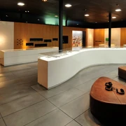 Ausstellung im Museum der BARUSSCHLACHT Moderne Museumsausstellung mit informativem Wandpanel, Glasvitrinen und bequemen Sitzgelegenheiten.