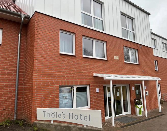 Thöles Hotel in Vilsen Backsteinfassade von Thöles Hotel mit großen Fenstern und einem überdachten Eingang in Vilsen.