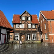 Weinhaus Nienburg Fachwerkhaus mit rotem Ziegeldach, historische Architektur zwischen zwei modernen Backsteinhäusern.