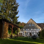 Naturfreundehaus Außenansicht Fachwerkhaus mit Garten und Bäumen, kombiniert traditionelle Architektur und grüner Außenbereich.