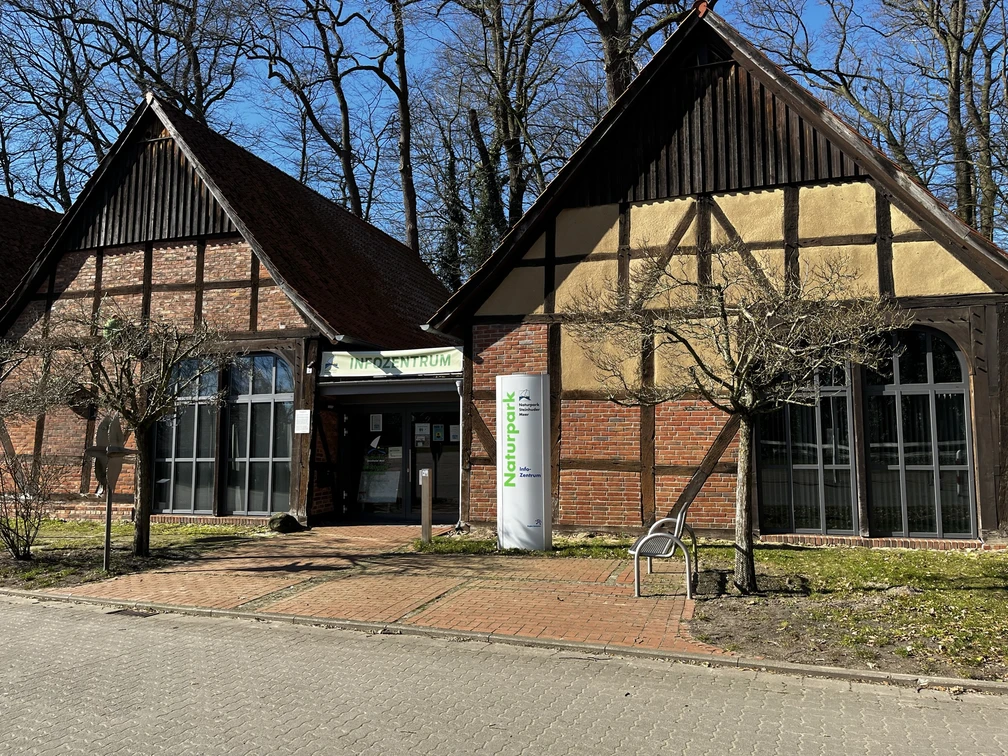 Naturpark-Scheune Steinhude Zwei traditionelle Fachwerkgebäude im Naturpark Steinhude mit großen Fenstern und Naturpark-Beschilderung.