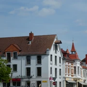 Speicher Scherf Historisches Backsteinhaus mit markantem Satteldach vor blauem Himmel in urbaner Umgebung.