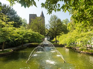 Springbrunnen von Schloss Landsberg bei Ratingen Springbrunnen mit Wasserstrahlen im Park von Schloss Landsberg, umgeben von grünen Bäumen.