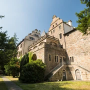Gebäude Schloss Landsberg mit kleinem Weg und Bäumen. Historisches Schloss mit Treppe, umgeben von Bäumen und einem schmalen Weg, aufgenommen bei klarem Himmel.