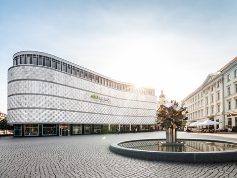 Blick auf die historische Fassade des Einkaufscenters Höfe am Brühl in Leipzig am Richard-Wagner-Platz mit einem Pusteblumen-Springbrunnen im Bild, Shopping in Leipzig