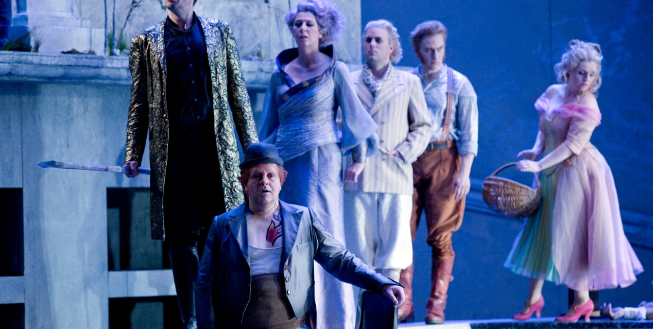 Sechs verkleidete Schauspieler:innen stehen auf einer in blau getauchten Bühne, Oper in Leipzig, Kultur