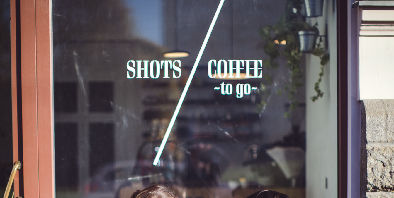 Zwei Frauen unterhalten sich auf einer Bank und trinken dabei Kaffee, Café in Leipzig, Gastro